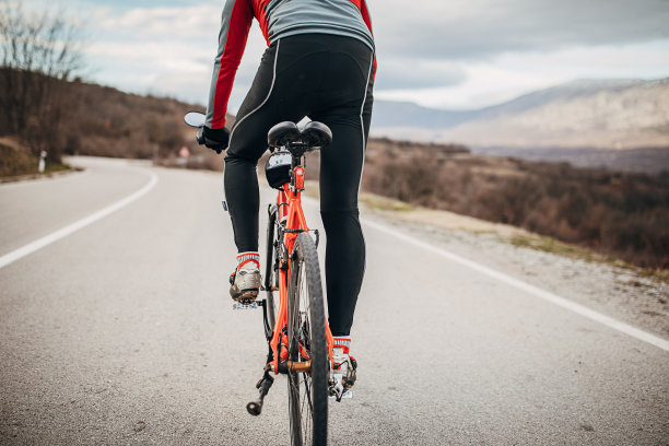 职业男性自行车手在路上骑自行车图片下载