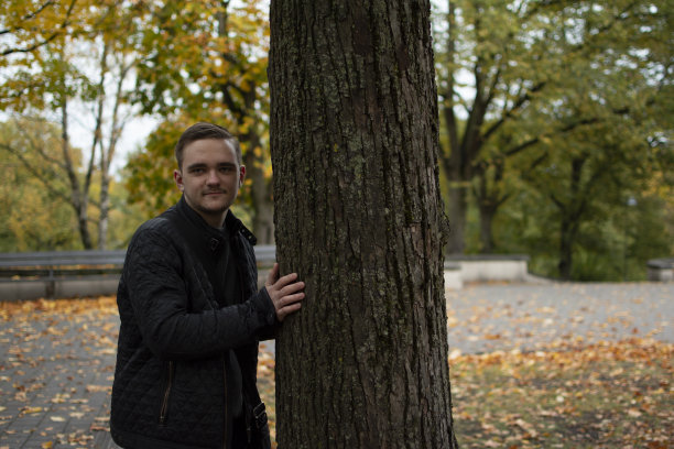 一个年轻的成年人站在公园里图片下载