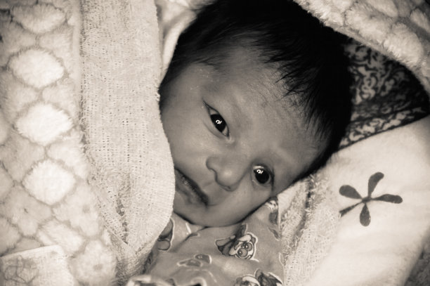 极端特写的新出生的亚洲印度男婴脸刚刚出生只有7天。裹着白色的毯子暖和的衣服。图片下载