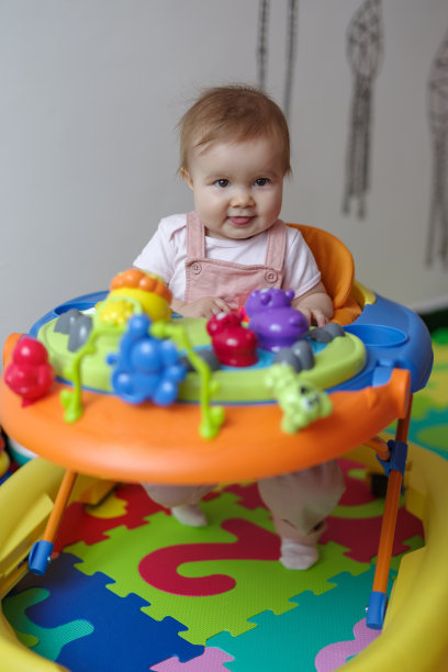 可爱的小女孩穿着学步车在家图片下载