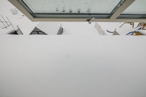 白雪覆盖的后院，从敞开的窗户可以看到美丽的风景。冬天的背景。图片下载