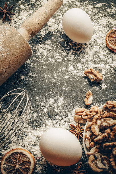 面包店组成。烹饪食物配料:面粉，鸡蛋，坚果和八角，橙色在黑暗的餐桌厨房背景蛋糕。俯视图拷贝空间。饼干、派或蛋糕食谱模型。图片下载