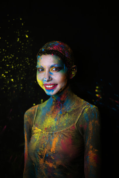 美丽的模特肖像与胡里彩色粉末艺术在黑色工作室的背景。图片下载