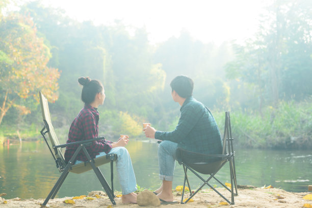 快乐的旅行者夫妇享受与自然的早晨，在湖上喝咖啡，放松的旅游度假概念。图片下载