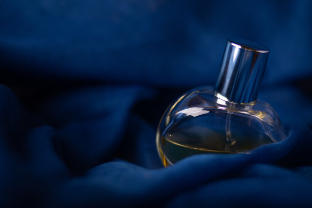 深蓝色香水的玻璃瓶，神秘而浪漫的背景。概念气味和近距离微距气味工作室拍摄。图片下载