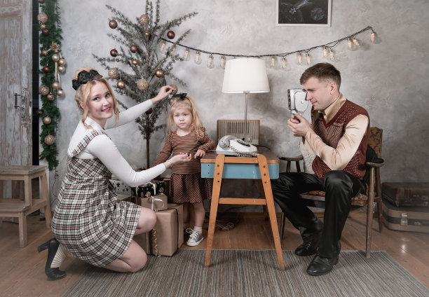 圣诞节那天，爸爸在家里用老式胶卷相机给一个孩子拍照片图片下载