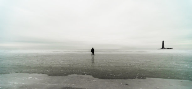 一个孤独的人的剪影和冰海上的灯塔图片下载