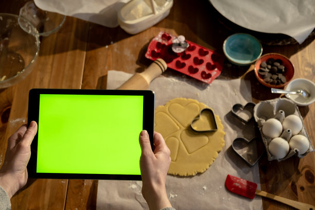 女人手持绿屏平板电脑观看教育图片下载