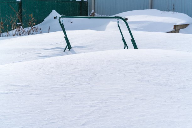 一场冬天的大雪后，花园秋千淹死在一堆雪中图片下载