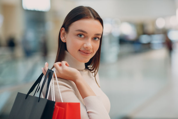 积极的年轻成年女性手里拿着纸袋购物图片下载
