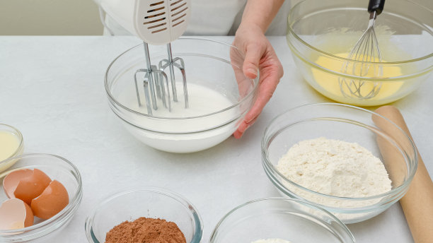 巧克力蛋糕的一步一步食谱。女人用手搅拌蛋清。关闭准备过程图片下载