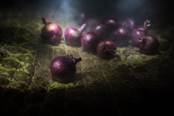 洋葱在黑暗。蔬菜食品，素食食品概念。有选择性的重点图片下载
