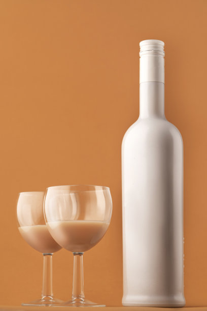 咖啡利口酒。白色牛奶色瓶子和两杯咖啡鸡尾酒，垂直照片图片下载