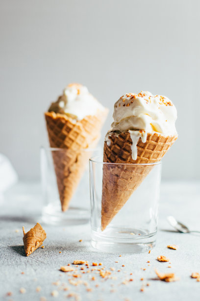 灰色背景上的两个白色冰淇淋在华夫饼杯的特写图片下载
