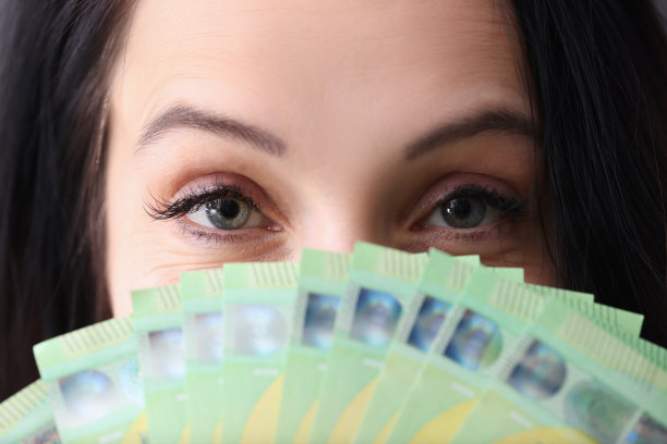 一个年轻女子，手里拿着一大笔现金图片下载