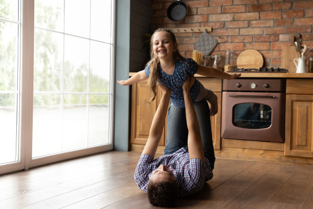 慈爱的爸爸和兴奋的小女儿在家里玩耍图片下载