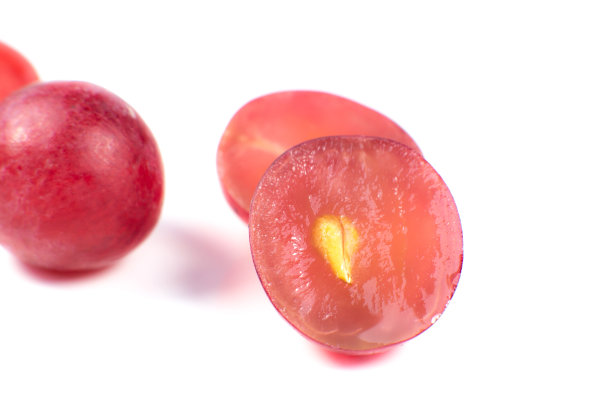 熟透的紫葡萄在白色的背景上切成两半。近距离的照片。纯素食者的生态水果。维生素。图片下载