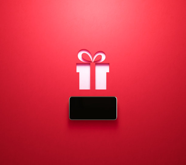 网上购物和约会的概念-智能手机坐在一个红色裁剪的礼盒象征形状在白色的背景图片下载