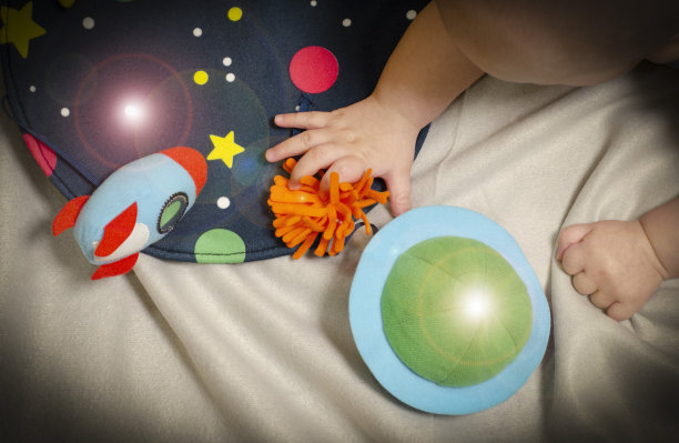 宝宝用小手触摸柔软的玩具。为孩子们准备的航天日图片下载