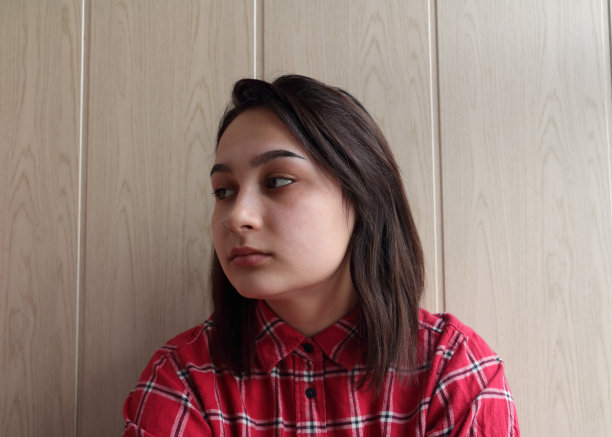 一个漂亮的年轻女人的家庭照片在墙上的背景。图片下载