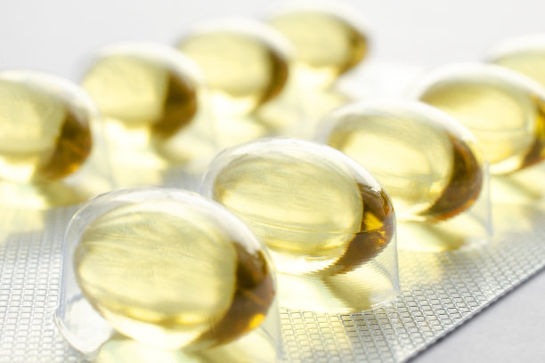 鱼油凝胶胶囊孤立在白色背景。白色背景下分离的黄色鱼油胶囊的包装。包装-3鱼油胶囊。黄色鱼油胶囊的特写。图片下载