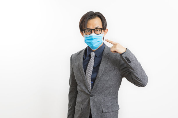 亚洲商人的肖像穿着衬衫和西装，戴着保护面罩在白色背景。图片下载