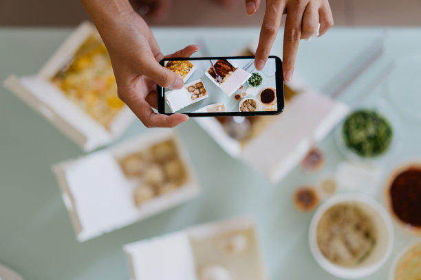 一名亚洲女性用智能手机拍摄她的外卖图片下载