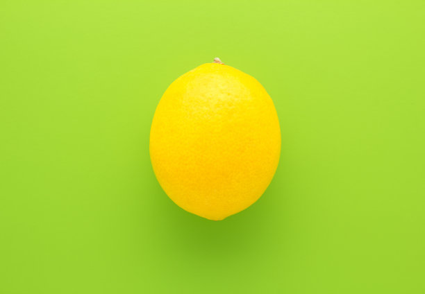 新鲜的黄色柠檬在绿色背景。前视图。图片下载