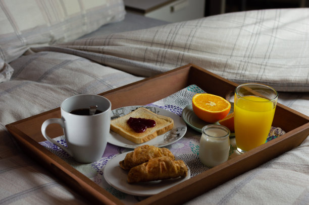 一个托盘和一个非常完整的早餐在床上的水平图像。浪漫的早餐概念图片下载