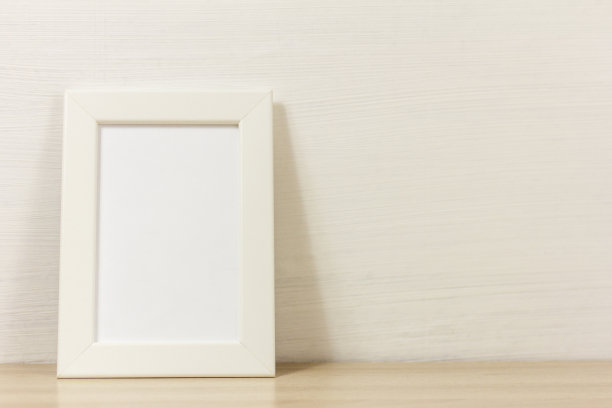 一个空的木制相框放在桌子或架子上，上面有一个空间的副本。图片下载