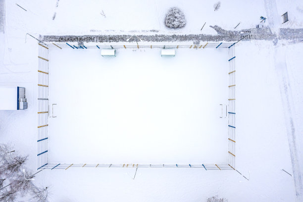 鸟瞰图，白雪覆盖的空旷运动场在公园。无人机摄影图片下载