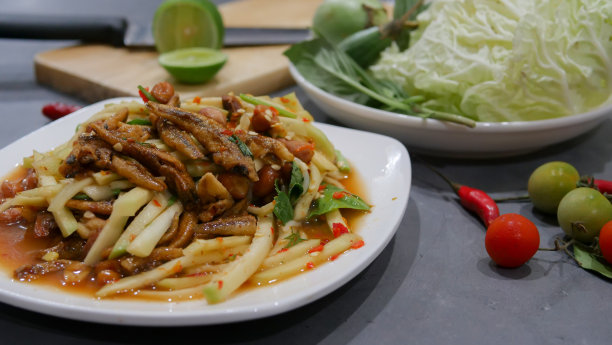 Yum芒果照片俯视图食物安排。辛辣的沙拉食物，上面有油炸的坚果和脆皮鱼。主要原料是生芒果、酸橙汁、鲜辣椒粉、鱼露、糖混合而成。让酸味带来。图片下载