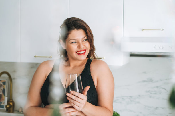 美丽快乐性感的黑发年轻女人加上大小身体积极与一杯红酒享受她的生活在家里图片下载