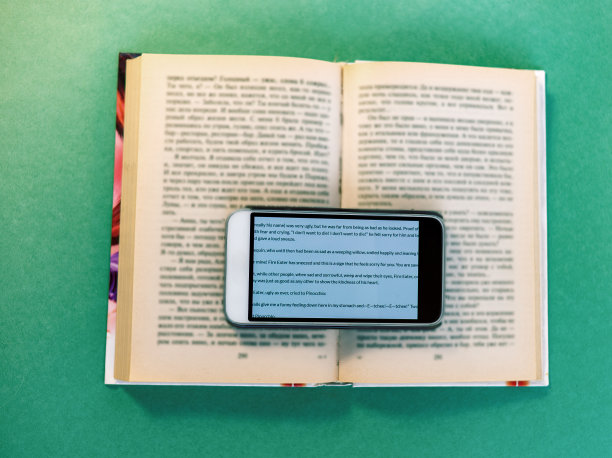 打开的书上有一部手机。一个新的现实。有选择性的重点。图片下载