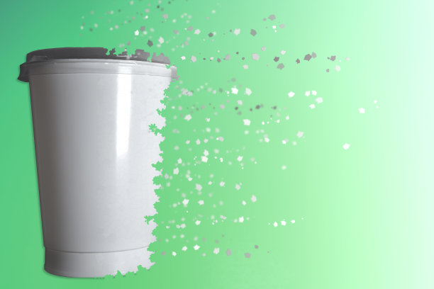 在绿色的背景下，塑料杯正在溶解图片下载