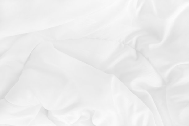 特写俯视图的白色床单和皱纹凌乱的毯子在卧室早上醒来后。图片下载
