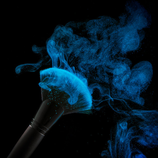 在黑色背景上的粉末。刷子化妆在黑色的背景。彩粉洒在流苏上。图片下载