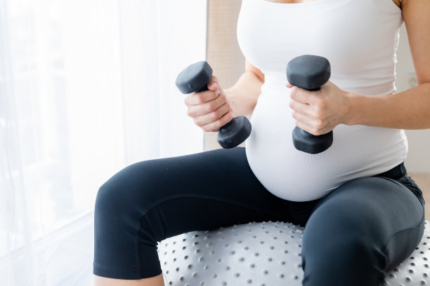 一个怀孕的年轻女人正在家里进行体能训练图片下载