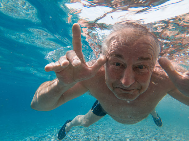 老年男子在海水中浮潜的水下照片图片下载