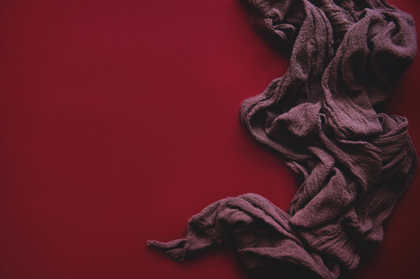 红色背景——红色纹理的织物。用于广告和展示的风格化照片。在艺术风格中，优雅的线条强调个性和独特性。图片下载