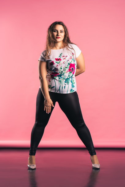 粉色背景上的大码模特，穿着休闲服装图片下载