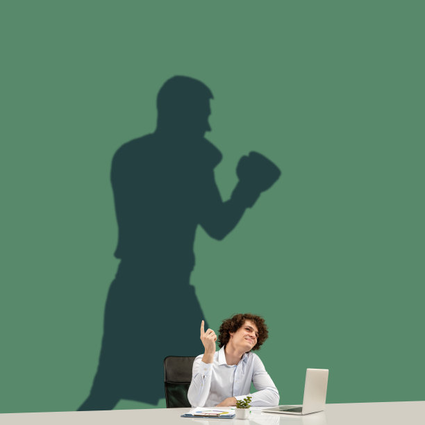 一个年轻人在办公室工作期间梦想着在大型体育运动中的未来。成为一个传奇。梦的影子在他身后的墙上。Copyspace。图片下载