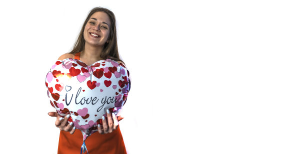 情人节快乐!一个拿着心形气球的年轻女子。副本的空间。图片下载