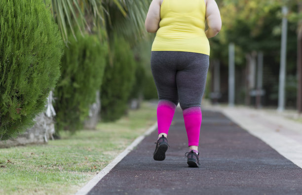 年轻的特大号妇女在公园里锻炼图片下载