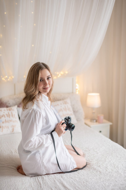 性感的女人在床上拍一张旧相机的照片图片下载