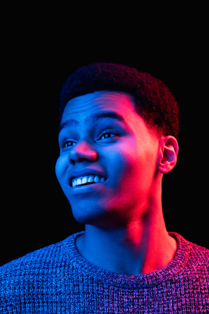 非裔美国人的肖像被隔离在彩色霓虹灯下的黑色画室背景上图片下载