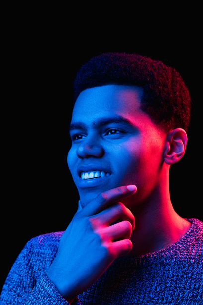 非裔美国人的肖像被隔离在彩色霓虹灯下的黑色画室背景上图片下载