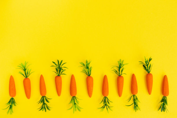 复活节图案与胡萝卜在明亮的黄色背景。复活节假期的概念。平的。图片下载