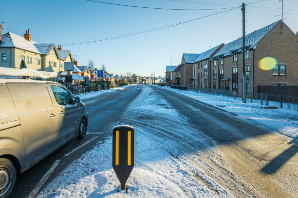 在英国，新冠肺炎封锁期间，开车行驶在英国小镇的冬季雪地路上图片下载