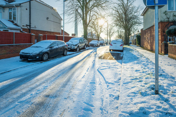 在英国，新冠肺炎封锁期间，开车行驶在英国小镇的冬季雪地路上图片下载